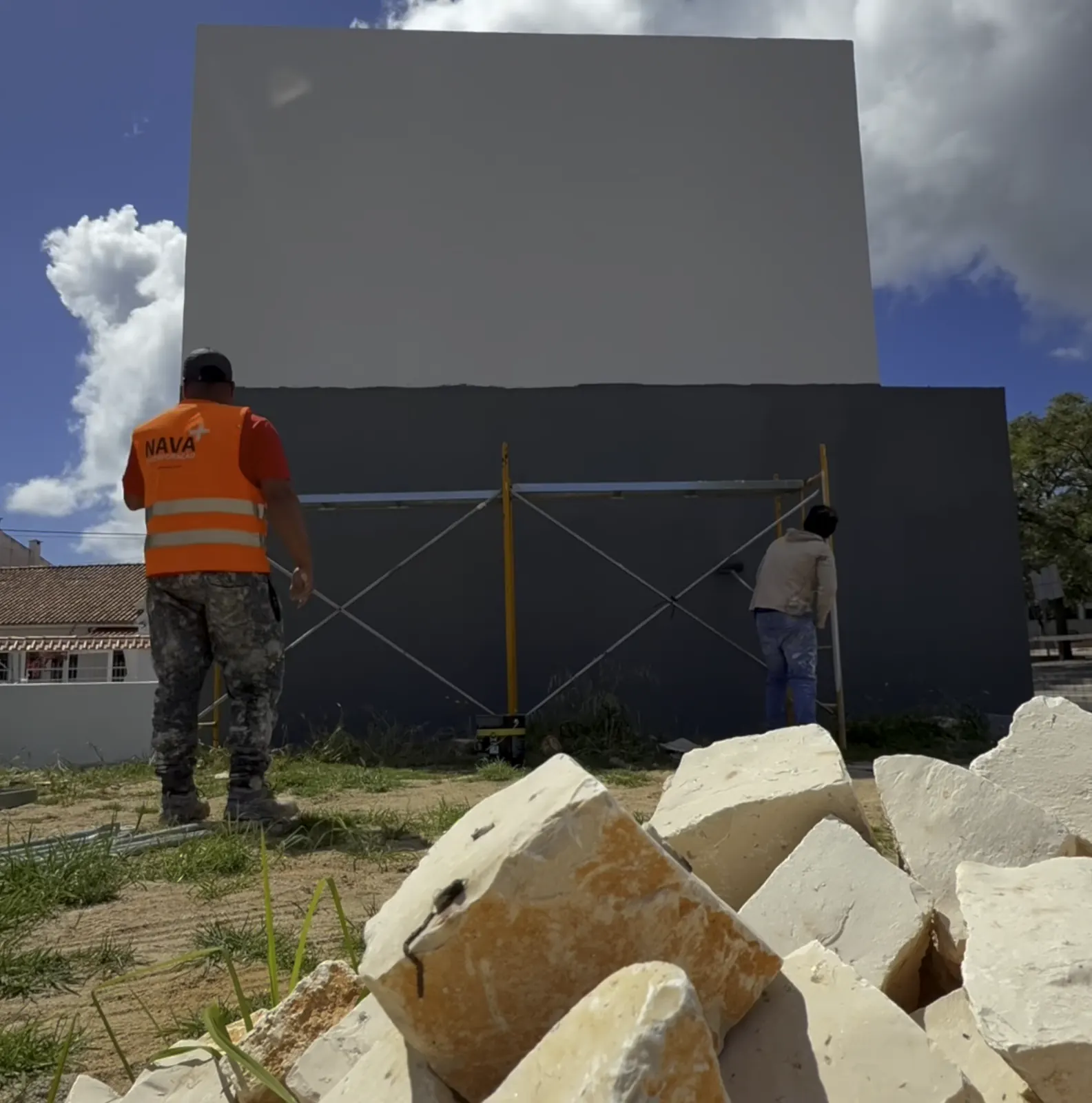 Dois pintores da Profinition num andaime a pintar a fachada cinzenta de uma moradia em Cascais