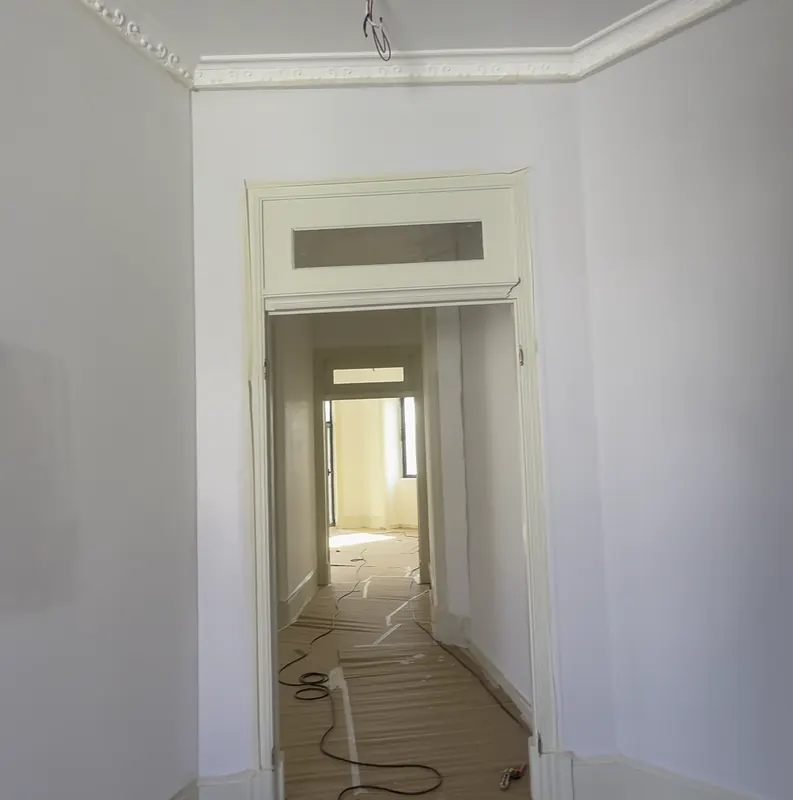 Corredor branco com portas antigas pintadas