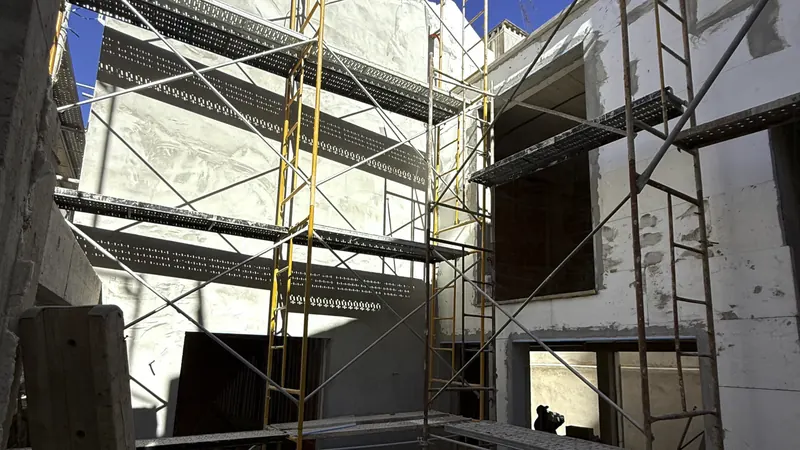 Fachada com placas de isolamento e andaimes montados