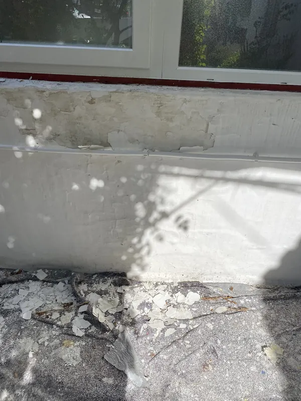Parede exterior com a tinta a descascar e o reboco degradado