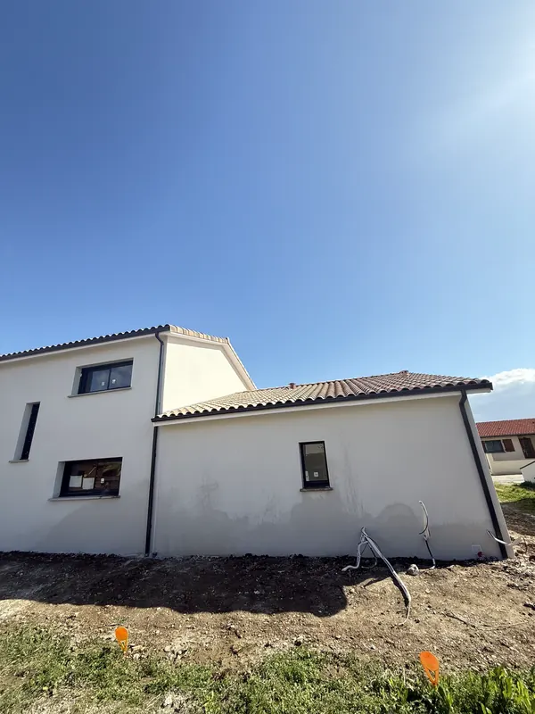 Moradia branca com o reboco acabado, ainda com terra à volta