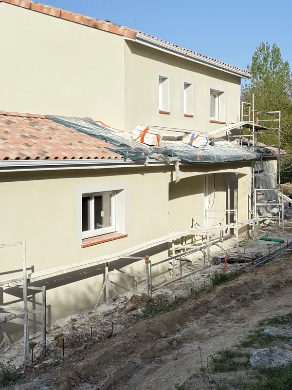 Moradia com andaime e reboco projetado aplicado