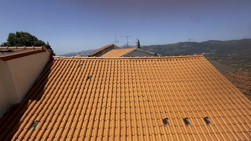 Telhado laranja acabado com vista para a serra